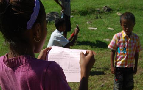 A girl from Timor Leste is looking at her storyboard on paper.
